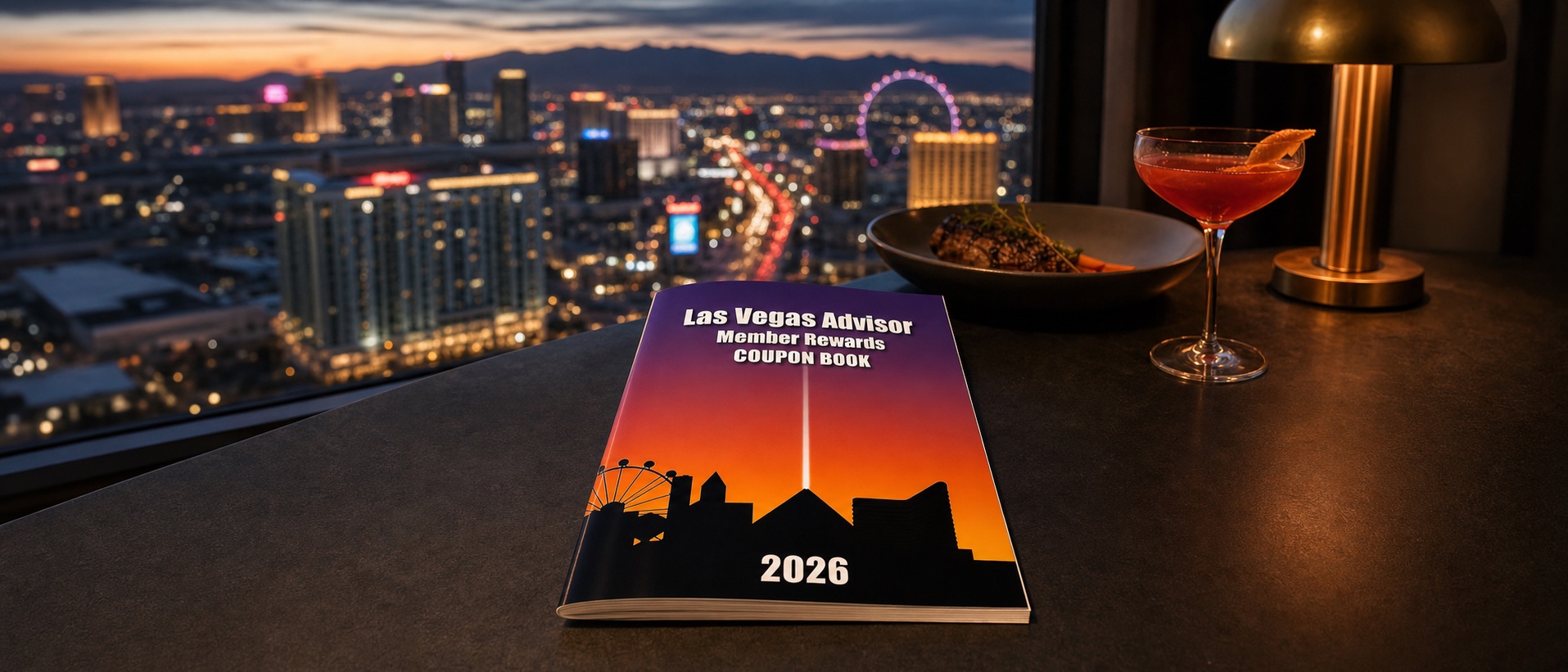 The 2026 Las Vegas Advisor Member Rewards coupon book on a table overlooking the Las Vegas Strip at dusk